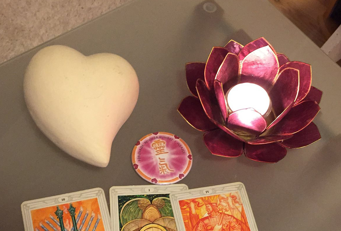 Medial vägledning för livets snurror. Bild på tarotkort , stenhjärta och Lotusljusstake.
